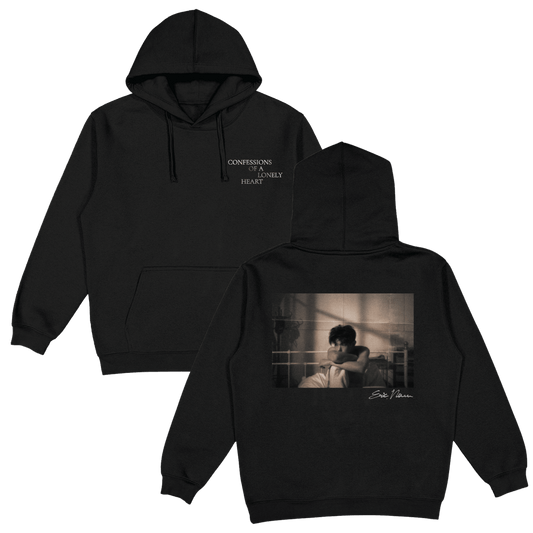 Black pullover hoodie shown from the front and back. The front has small white text reading 'CONFESSIONS OF A LONELY HEART' on the left chest and the back features a photo of Eric Nam