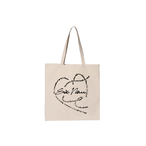 A beige canvas tote bag with two shoulder straps, featuring a black printed graphic on the front that reads 'Eric Nam' in script and block lettering